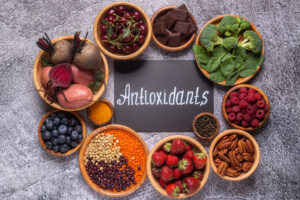 Image of foods high in antioxidants in bowls surrounding a sign that says antioxidants