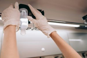 A person with gloves on setting up an IV bag