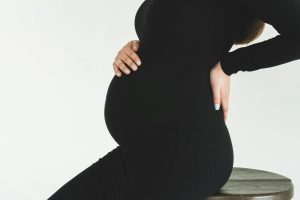 Pregnant woman sitting on a stool