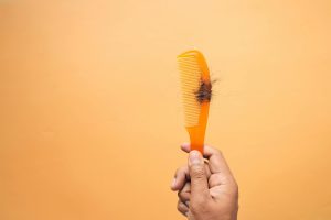 Person holding a brush with hair in it