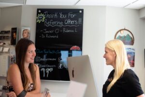 Patient speaking with clinic staff in a Boulder wellness clinic discussing fatigue and recovery options.