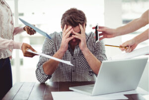 Man experiencing stress, fatigue, and mental exhaustion during a busy workday